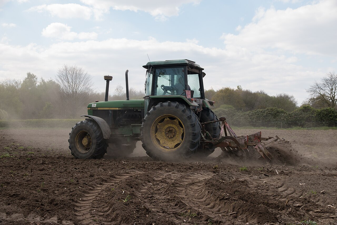 Tractor with plow working a field